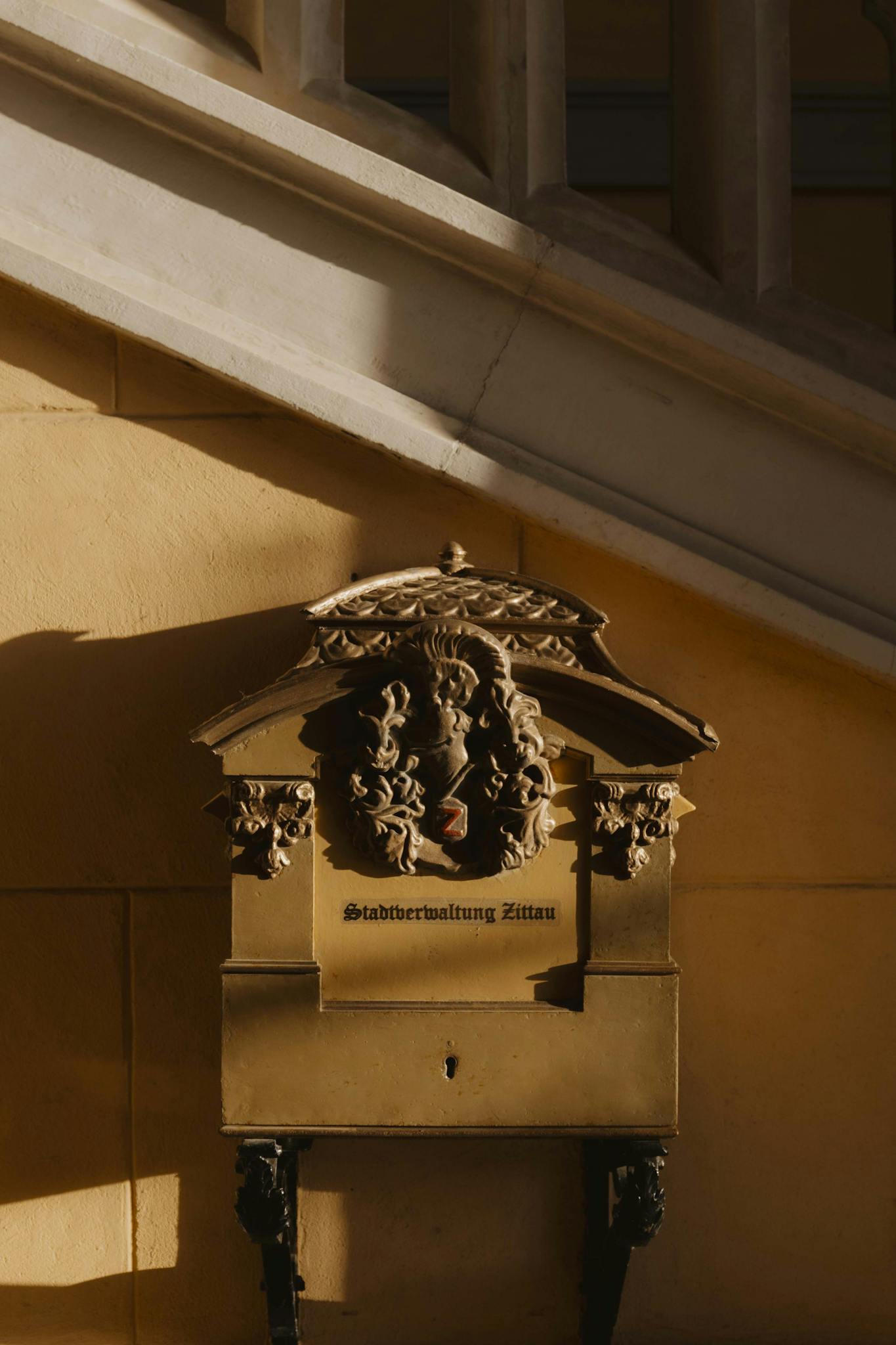 Close-up of a decorative mailbox in sunlight at Zittau town hall, Germany.